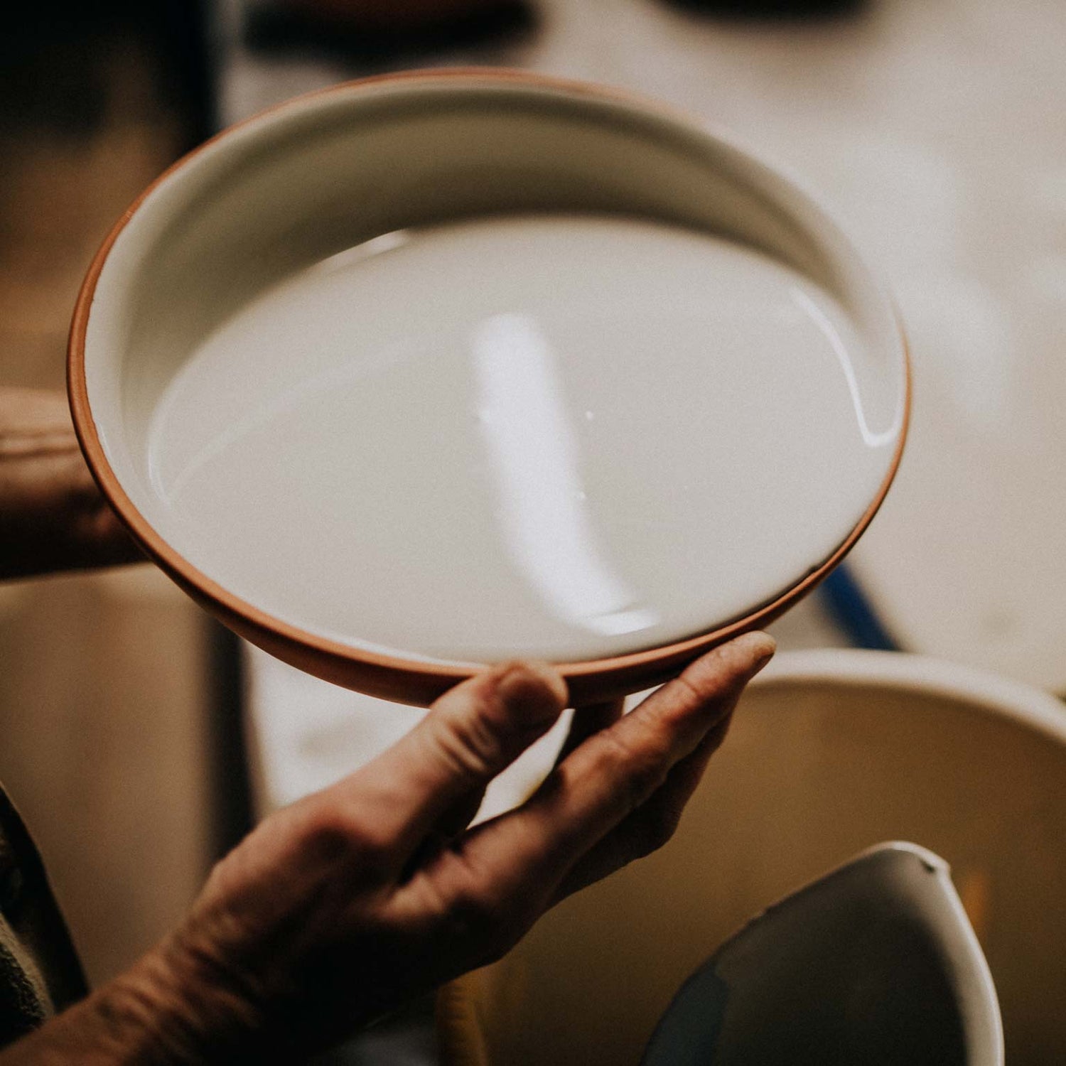 Glazing the inside of a small terracotta bowl