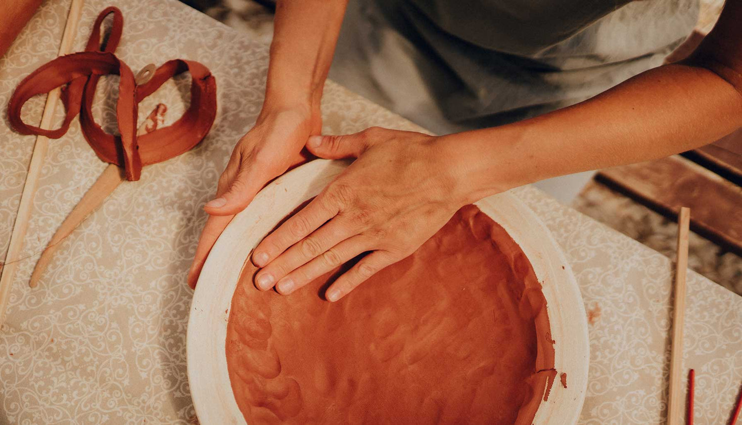 Forming a clay plate at ceramics workshop